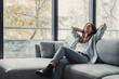 © Daniel - Relaxed serene pretty young woman feel fatigue lounge on comfortable sofa hands behind head rest at home, happy calm lady dream enjoy wellbeing breathing fresh air in cozy home modern living room.