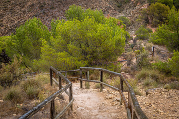 Footpath to the La Cruz memorial, Benidorm, Image shows a public footpath cut into the ground from the rock and man made railings to assist hikers in the steep walk to the memorial