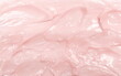 Pink cosmetic cream spread, spilled background and texture
