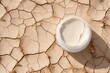 Open container of hydrating skin cream contrasting with the parched, cracked earth, symbolizing skin care and moisture restoration. Moisturizing Cream on Cracked Earth Texture