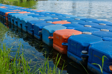 Floating pier made of composite plastic blocks on the river, sea. Plastic bridge on a lake