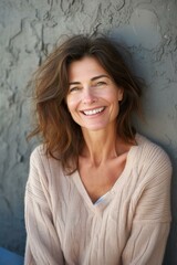 Wall Mural - portrait of a smiling woman with long brown hair wearing a beige sweater