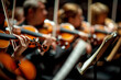 An orchestral concert with many violins performs on stage.