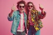 © Dina - caucasian couple models man and woman  dancing in 80s style clothes on pink background, smiling and showing thumbs up. Cheerful guy dance with copy space. Vintage fashion outfit shopping. Disco party.