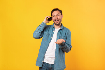 Aufkleber - A man is holding a cell phone up to his ear, engaging in a phone conversation. He appears focused and attentive as he communicates through the device.