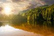 tranquil landscape with lake in summer at sunset. forest reflection in the calm water. beautiful nature scenery in evening light. peaceful green outdoor environment
