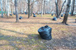 A park with many bags of trash scattered around