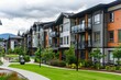 © inspiretta - a row of multi - story apartment buildings with a green lawn in front of them and a cloudy sky