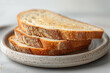 Sliced bread on plate on white table, closeup view