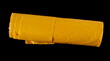 Yellow plastic garbage bag, isolated on black, top view
