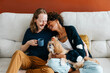 Affectionate couple relaxing with their dog on sofa at home