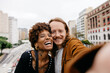 Joyful couple taking a selfie together on city streets
