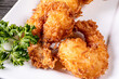 © SockaGPhoto - Close up of a plate of deep fried coconut shrimp with a red dipping sauce