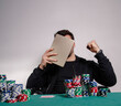 Unrecognizable man poker player, playing poker online on tablet and winning , tablet covering his face