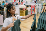 Fototapeta  - A young girl is shopping for clothes in a store