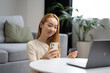 © puhhha - Young Woman Using Smartphone And Credit Card At Home: A Smiling Asian Woman Engages With Mobile Payment or Online Shopping, Reflecting Comfort And Technology In Living Room.