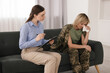 Psychotherapist working with military woman on sofa in office
