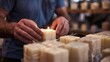 A man meticulously wraps his finished candle in elegant packaging ready to be sold at a local artisan market.