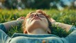 A person lying on their back on a grassy field eyes closed and focused on their breath as they recharge and find balance.