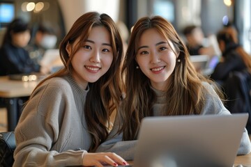 Wall Mural - Two smiling Asian women sit in front of their laptops, exuding happiness and focus in a modern, brightly lit corporate office setting Cinematic Mood and tone.
