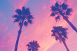 This retro-style photograph captures the timeless allure of palm trees set against a vivid backdrop of pink and purple hues in the sky. Reminiscent of vintage postcards and '80s aesthetics