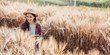 © Satori Studio - Young agriculturist with a digital tablet is closely examining wheat quality in a sunlit agricultural field.