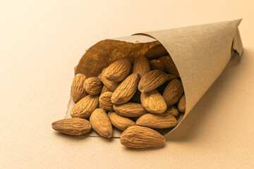 Wall Mural - Almonds in a paper bag on a beige background.