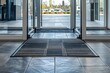 threshold made of gray ceramic tiles at entrance to store with a rubber foot mat and open glass door with metal handle at office building close-up front view, nobody