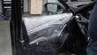 A man sprays cleaning foam on the interior of a car.