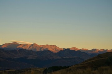 Wall Mural - Envision the majesty of a mountain range at sunrise, with golden light painting the peaks in hues of pink and orange, casting long shadows, Generative AI