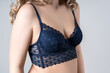 Blonde woman in blue push up bra on gray background, decollete area care