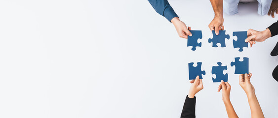 Top view panorama banner of business team joining jigsaw puzzle together over meeting table symbolize business partnership and collective unity teamwork in problem solving solution. Prudent