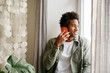 © Westend61 - Smiling man talking on mobile phone sitting by hanging decor at home
