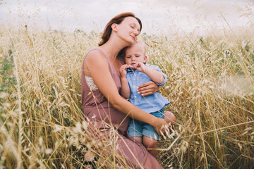 Wall Mural - Pregnant woman and son on nature. Mother waiting of a second baby.