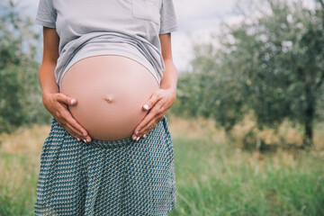 Wall Mural - Close-up of pregnant belly in nature