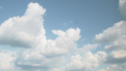 Wall Mural - Slow moving romantic cumulus clouds. Blue sky with several layers of clouds.