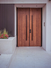 Poster - A modern design house entrance with a wooden door, black fence and colorful flowers. Travel to Athens, Greece.