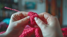   A Tight Shot Of Someone Crocheting, With A Pink Yarn Ball In The Foreground And Another Visible Behind