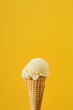Single vanilla ice cream cone on yellow