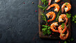 Board of tasty shrimp tails and herbs on black background