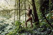 Sexy girl in bikini in tropical forest. Woman relaxing on nature