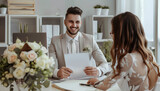 Fototapeta Desenie - Male wedding planner working with couple in office