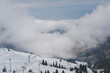 Cable car at a ski resort. Clouds over snowy mountain peaks, beautiful landscape