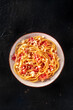 Carbonara pasta dish, traditional spaghetti with pancetta and cheese, shot from the top on a black background