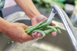 Woman hands washing fresh green beans in a kitchen
