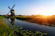 Windmill near water in sunlight in the Netherlands.