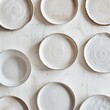 © Qstock - Overhead View Assorted Ceramic Plates on White Textured Background