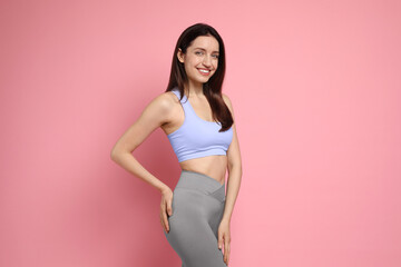 Wall Mural - Happy young woman with slim body on pink background