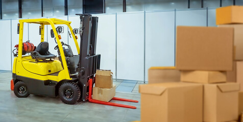Poster - Forklift near cardboard boxes. Storage equipment. Forklift for unloading goods. Storage technologies. Electric forklift inside distribution center. Technique for logistics processes.