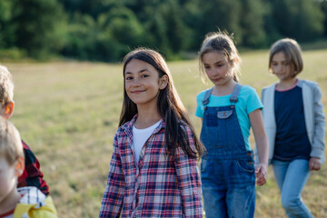 Canvas Print - Young students walking across meadow during biology field teaching class.. Dedicated teachers during outdoor active education teaching about ecosystem, ecology.